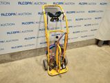 a yellow cart with a hose attached to it in front of a blue and white wall
