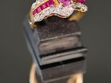 gros plan d'une bague en or avec un rubis et des diamants
