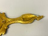 a gold spoon and spoon rest on a white surface