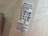 a white power supply sitting on a bed next to a remote control