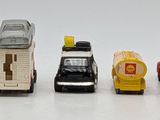 several toy cars are lined up in a row on a white surface