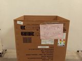 a cardboard box sitting on a pallet in the middle of a room