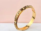 a close up of a gold ring on a marble surface