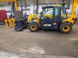 un engin de chantier jaune et noir garé dans un entrepôt