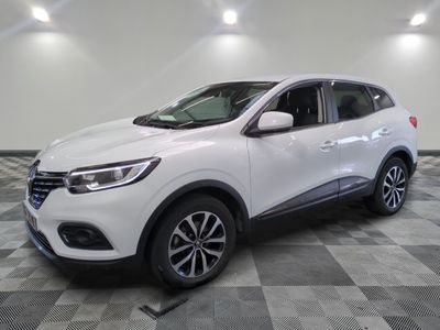 un 4x4 blanc garé sur un sol en damier dans un garage