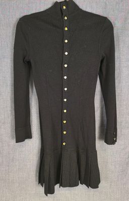 un pull noir pour femme, orné de boutons dorés sur le devant