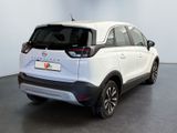 the back of a white car parked in a large room
