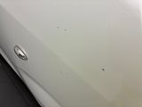 a close up of a white car with a hole in the door