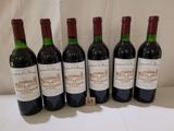 six bouteilles de vin sont alignées sur une table