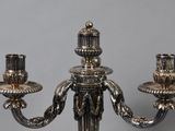 a silver candelier with three candles on it
