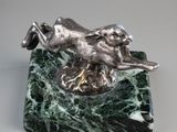 figurine de chien en marbre argenté et vert, posée sur un socle en marbre