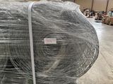 many rolls of wire wrapped in plastic in a warehouse