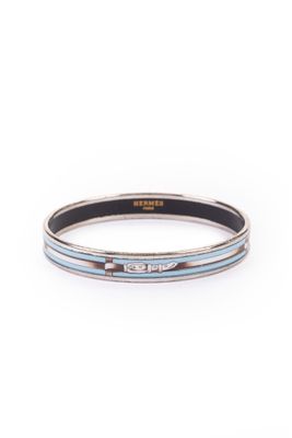 un gros plan d'un bracelet argenté et bleu sur fond blanc