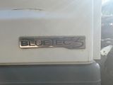 a close up of a white truck with a blue eq logo on it