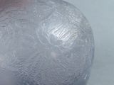 a glass ball with frost on it sitting on a table