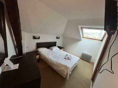 une photo d'une chambre à coucher avec un lit et une télévision à écran plat