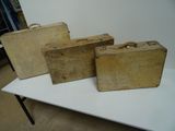 Trois vieilles valises sont posées sur une table dans une pièce