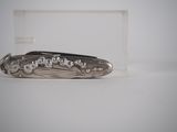 a silver knife that is laying on a table