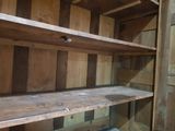 a wooden shelf in a room that has a lot of shelves
