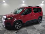 the red van is parked on a checkered floor in a garage