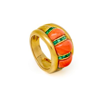 a close up of a gold ring with red and green stones