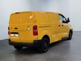 the rear end of a yellow van parked in a room
