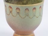 a green and brown bowl on a white surface