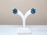 pair of blue crystal earrings on a white stand on a white table
