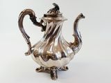 an antique silver tea pot with a handle on a white background