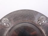 a silver plate with a design on it on a table