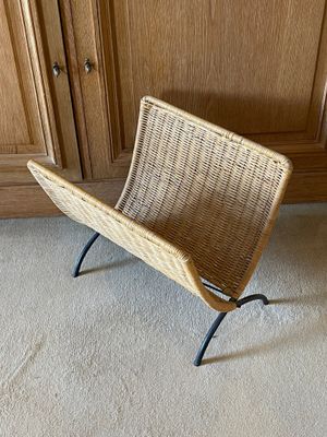 une chaise en osier dans un coin de la pièce