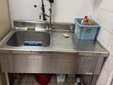 un lavabo dans une salle de bains, avec une poubelle à côté