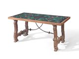 La table est en bois et son plateau est recouvert de carreaux noirs et verts.