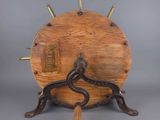 an image of a wooden clock on a stand with a snake on it