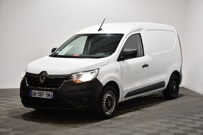 la camionnette blanche est garée dans une pièce au sol en damier