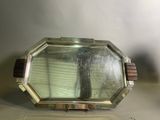 un petit miroir posé sur une table près d'un mur