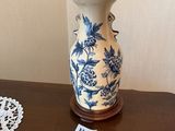 un vase bleu et blanc posé sur une table à côté d'une lampe