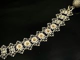 bracelet en argent orné de fleurs et de perles sur un fond noir