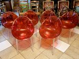 quatre chaises en plastique rouges posées sur un sol carrelé