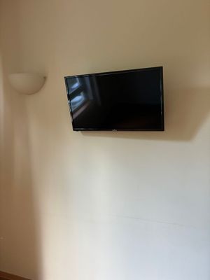 une télévision à écran plat fixée au mur dans un coin de la pièce