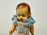 a small doll with a crocheted dress on it