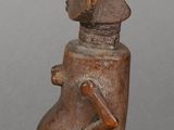 wooden sculpture of a man with a hat and a bird on his head
