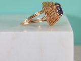 a close up of a gold ring with a purple stone on it
