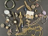 an assortment of jewelry including a watch, bracelets, rings, and other items