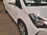 a white toyota yaris parked in a parking lot