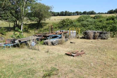 a lot of junk in a field with trees in the background