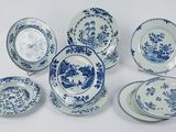 plusieurs assiettes et bols bleus et blancs posés sur une surface blanche
