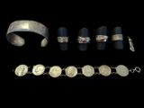 several silver bracelets and rings are shown on a black background