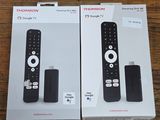 two boxes of remote controls sitting on a wooden table