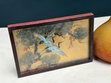 a picture of a bird and a pear on a table